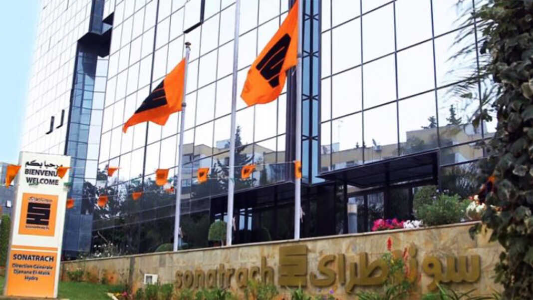 Bâtiment de Sonatrach avec drapeaux Façade moderne de Sonatrach avec drapeaux orange et noir.
