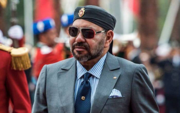 Homme en uniforme militaire avec lunettes de soleil et chapeau.