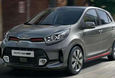 Voiture Kia Picanto 2023 gris foncé en déplacement urbain.