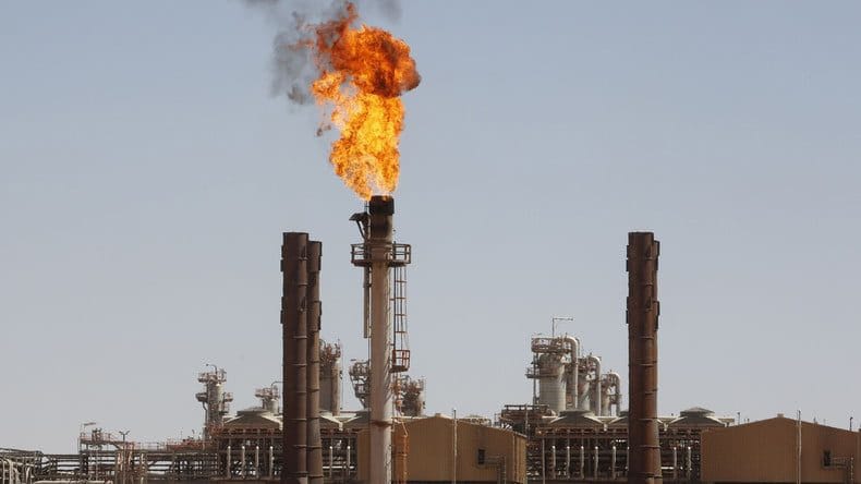 Fumée et flamme sortant d'une cheminée industrielle en feu.