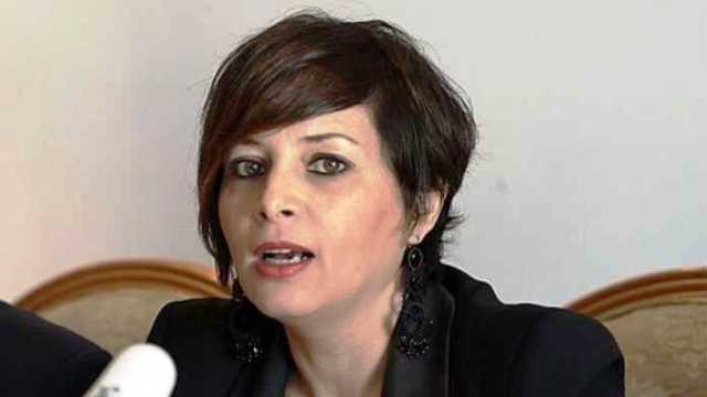 Femme politique parlant lors d'une interview, expression sérieuse.