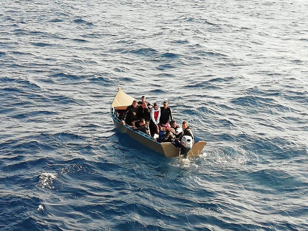Groupe de migrants en bateau sur la mer, recherche de refuge ou d'asile.