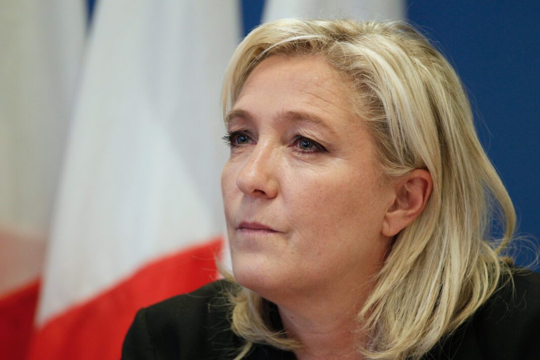Femme politique blonde lors d'une réunion officielle en France.