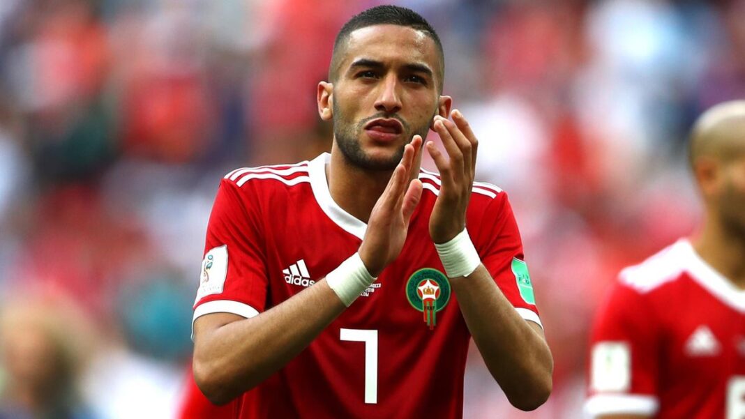 Footballeur marocain portant maillot rouge lors d'un match.
