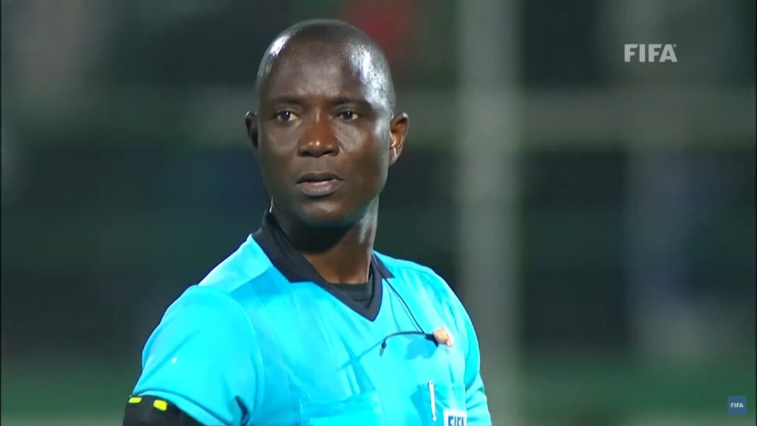 Arbitre de football professionnel en pleine action sur le terrain.