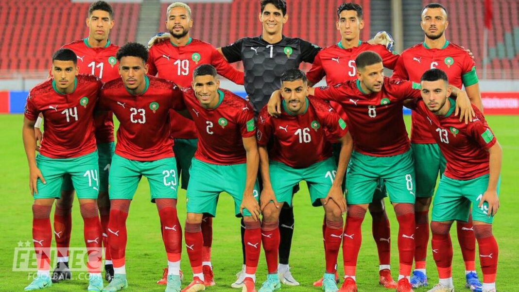 Groupe de joueurs marocains en maillot rouge et vert sur le terrain.