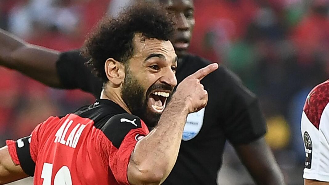 Footballeur célébrant un but avec enthousiasme sur le terrain.
