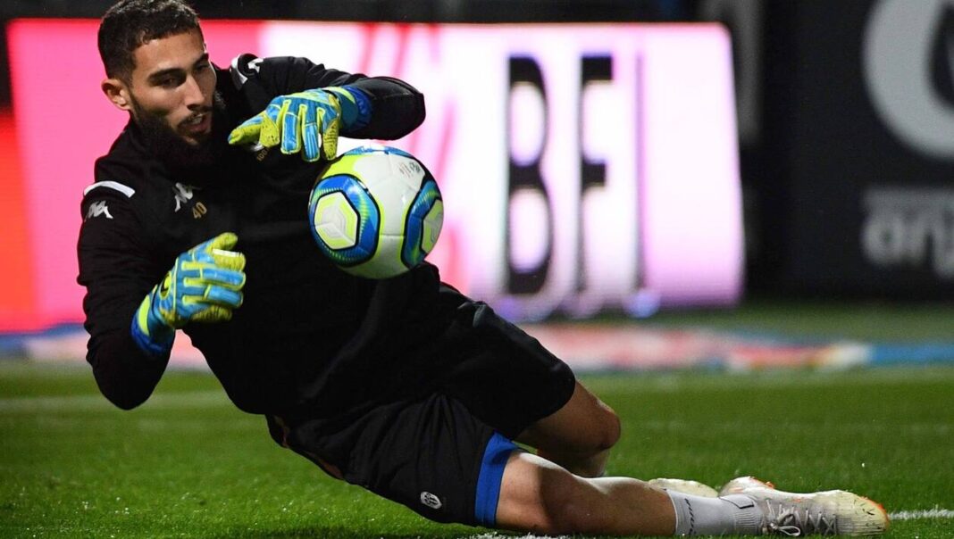 Jeune gardien de but en pleine action avec le ballon lors d'un match de football.
