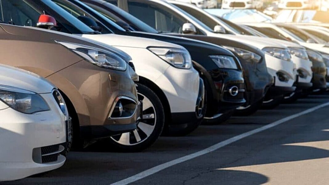 Ligne de voitures modernes garées dans un parking en plein jour.