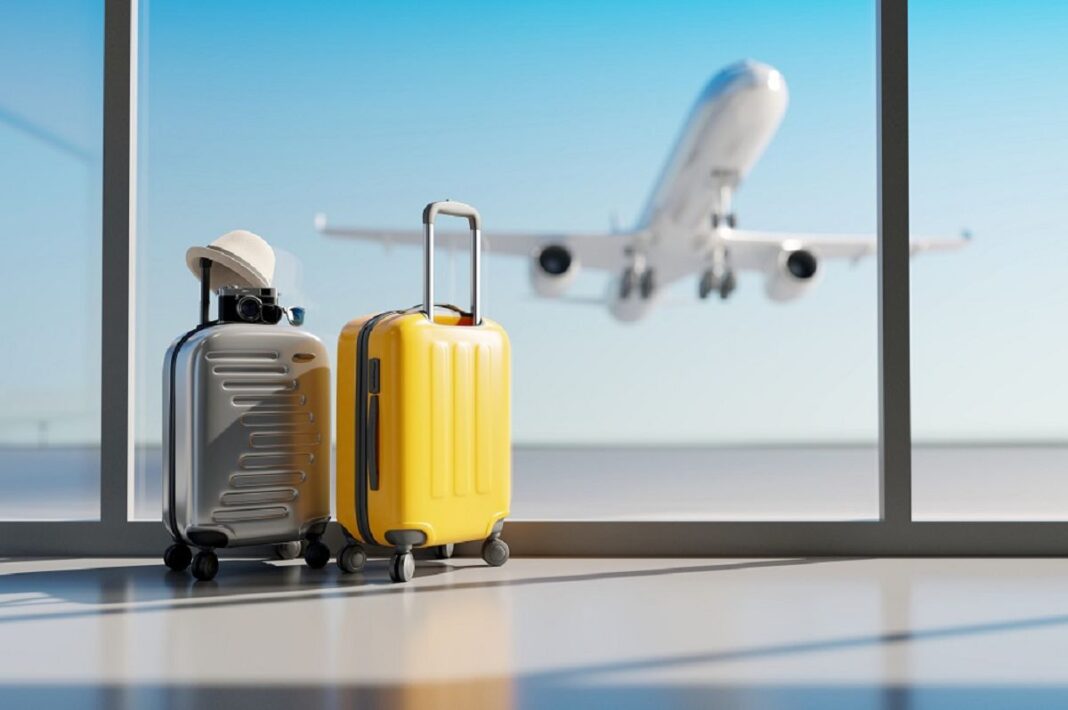 Valises de voyage près de la fenêtre avec avion en vol en arrière-plan.