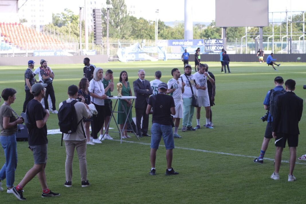 Spectateurs et joueurs sur le terrain lors d'un match de football.