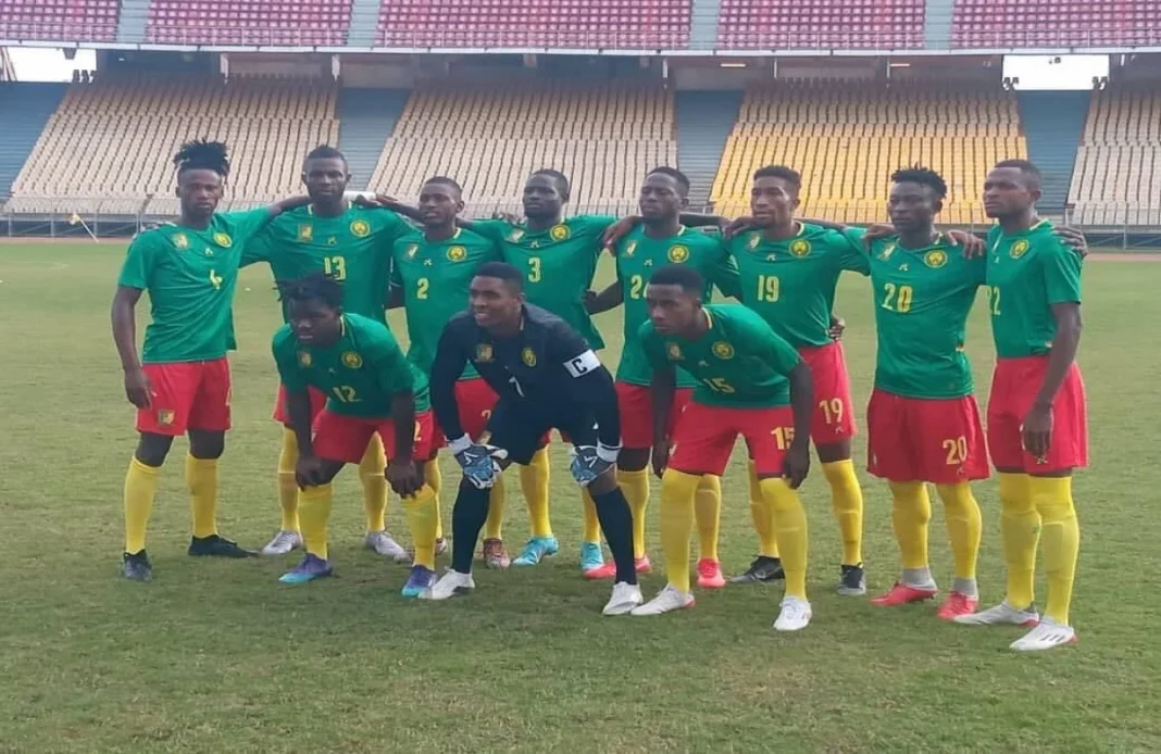 Groupe de joueurs camerounais en tenue de match sur le terrain.