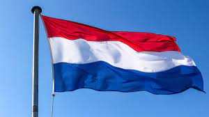 Drapeau des Pays-Bas flottant dans le ciel bleu clair.