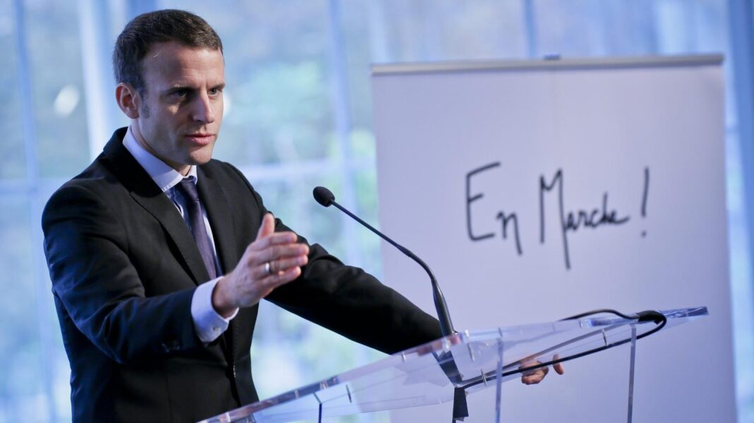 Homme politique lors d'un discours avec un panneau "En Marche!".