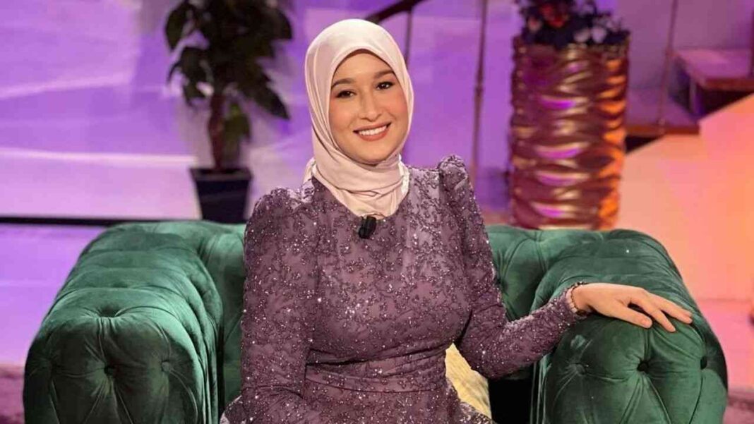 Maya Redjil souriante en tenue élégante lors d'une interview.