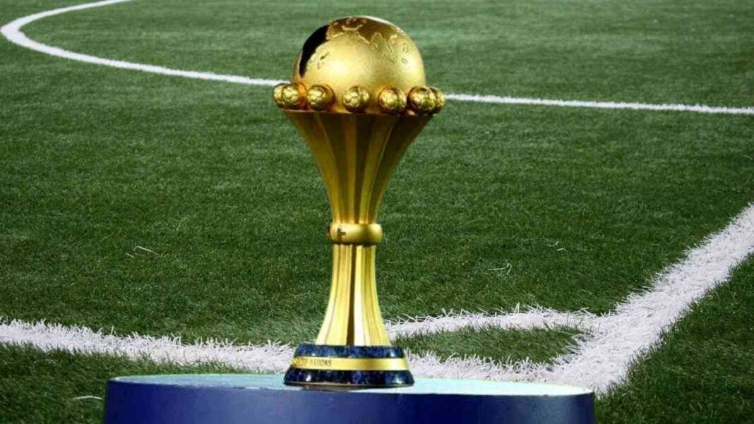 Trophée de la CAN 2025 sur le terrain de football vert.