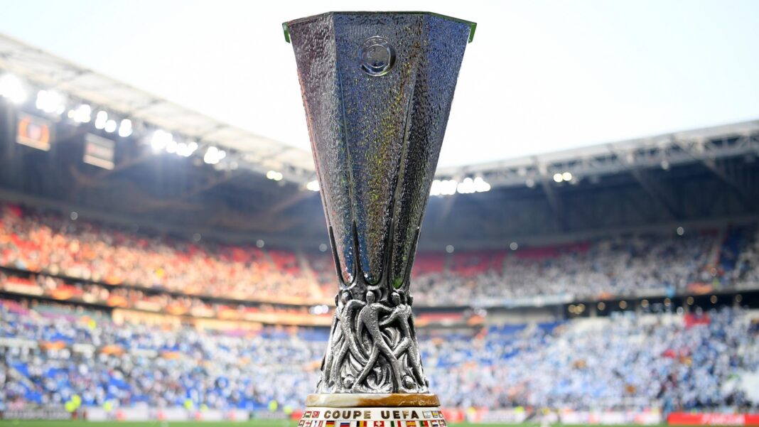 Trophée de la Ligue Europa dans un stade rempli de spectateurs.