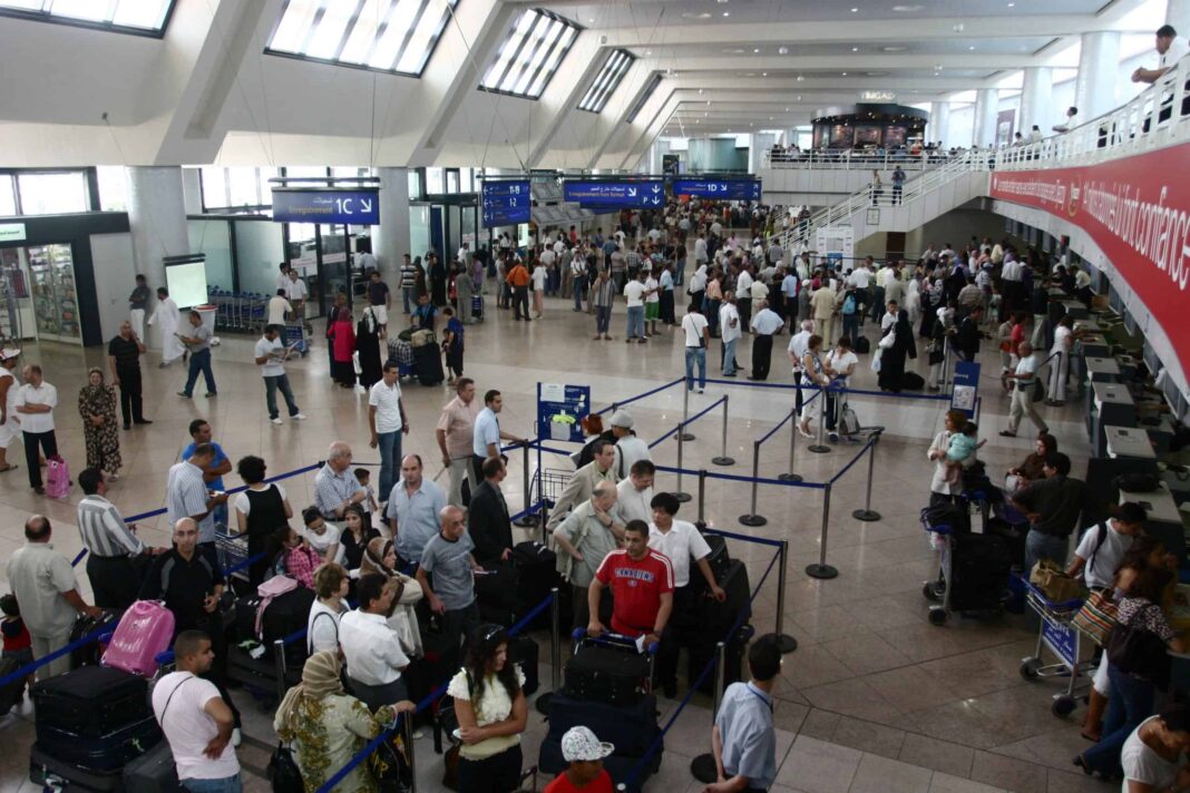 Aéroport avec nombreux passagers Passagers à l'aéroport en attente de leur vol.
