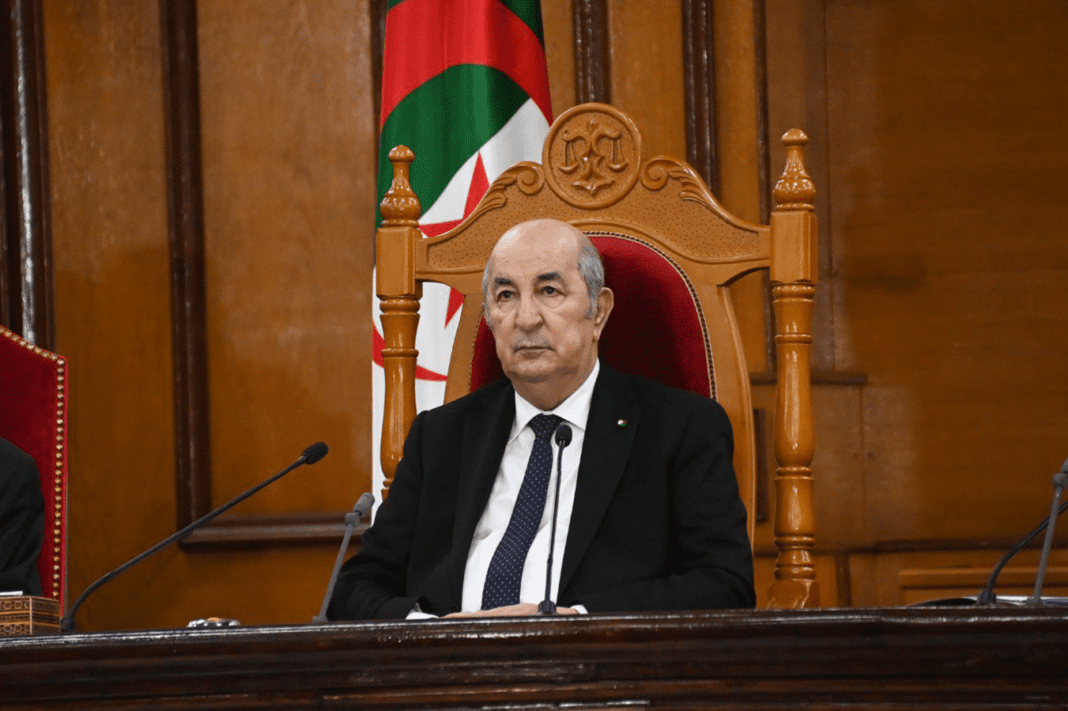 Président Tebboune assis lors d'une réunion officielle en Algérie.