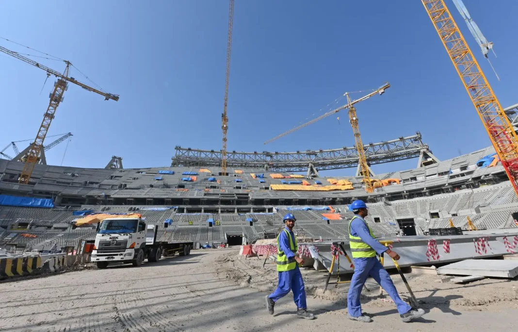 Construction du stade au Qatar Travailleurs sur le chantier du stade au Qatar sous un ciel clair.