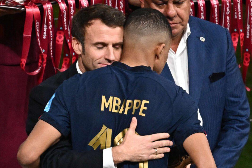 Emmanuel Macron serre Kylian Mbappé lors d'une cérémonie sportive.