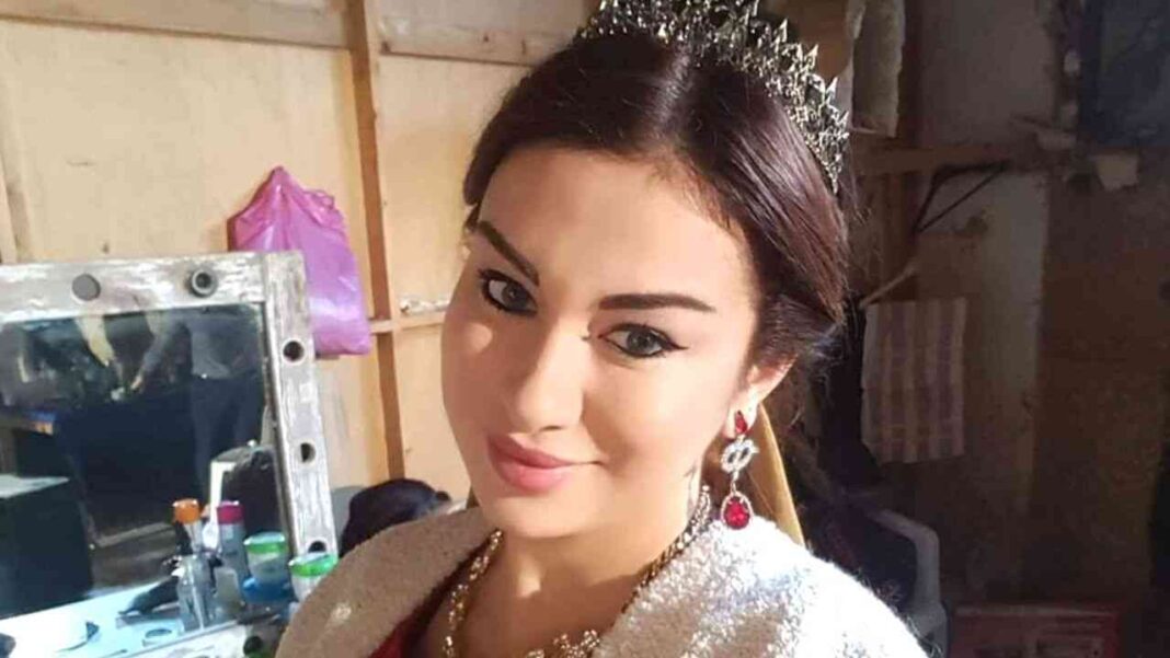 Rym Ghazali souriante portant une robe élégante et un diadème.