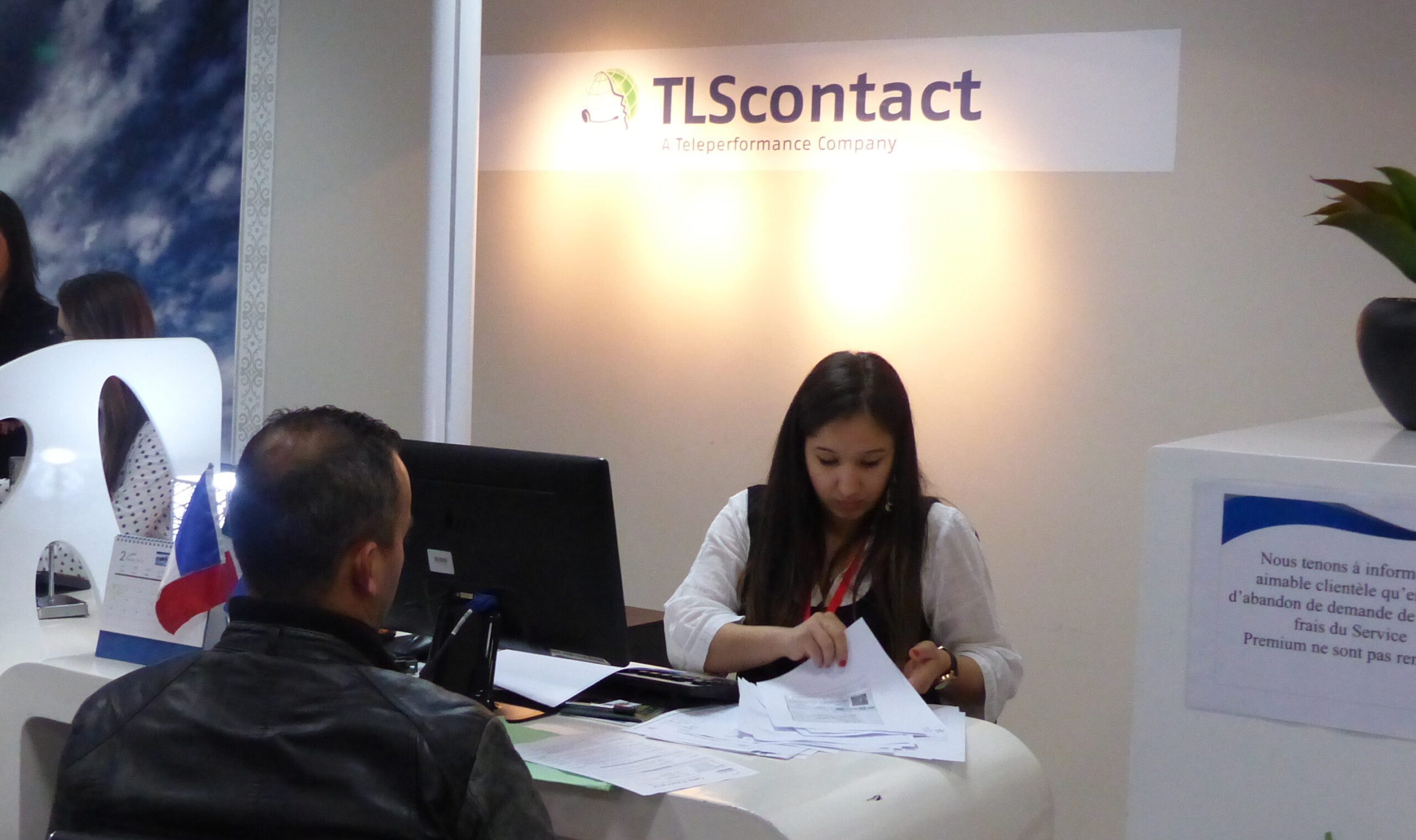 TLSContact annonce la fermeture temporaire de France-Visas : Détails et conseils Agent TLScontact aidant un client pour demande de visa.
