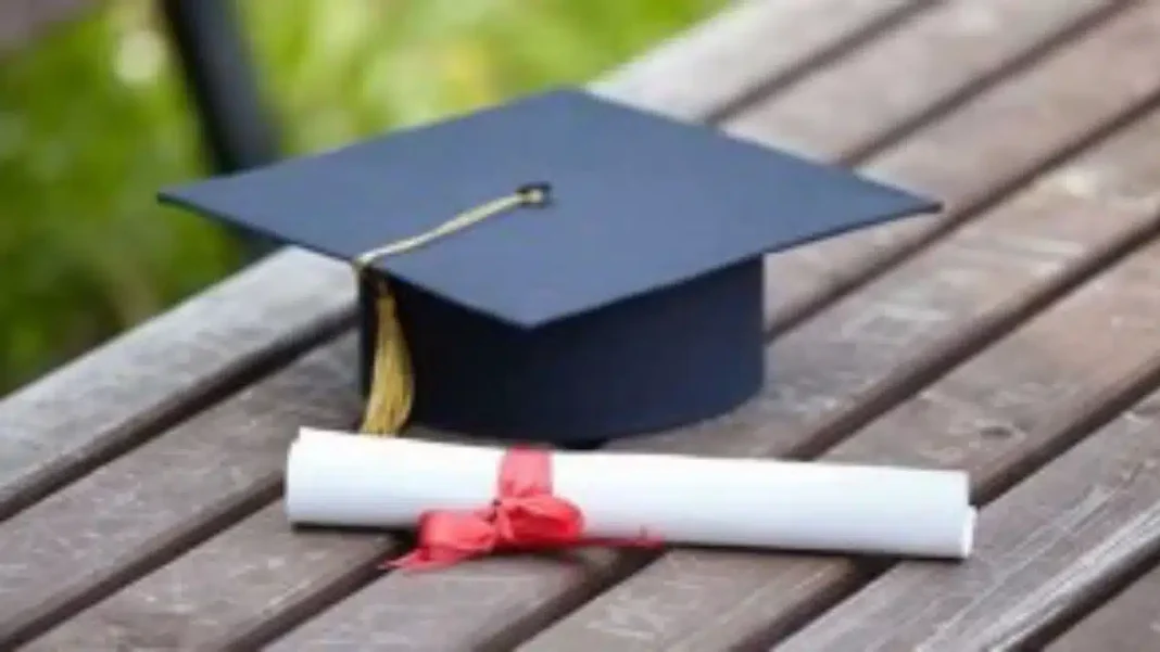 Diplôme et chapeau de graduation sur une table en bois.