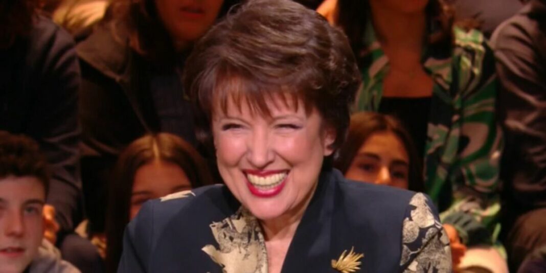 Roselyne Bachelot souriante entourée de jeunes lors d'une rencontre publique.