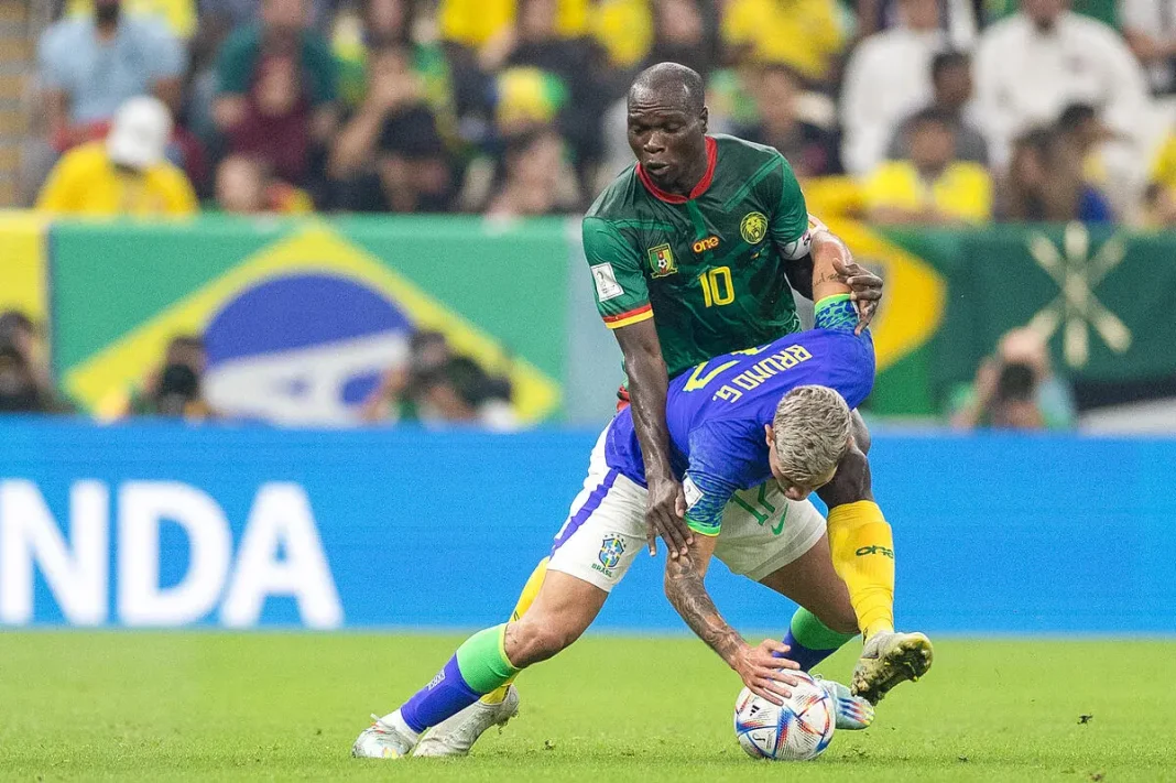 Joueur brésilien et joueur africain en duel lors d'un match de football.