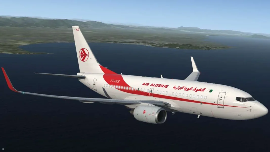 Avion d'Air Algérie survole la mer avec paysage montagneux en arrière-plan.