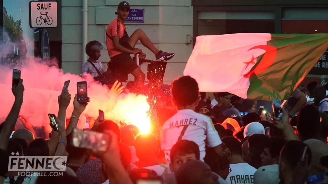 Manifestation en Algérie avec drapeaux et fumigène, foule de manifestants.