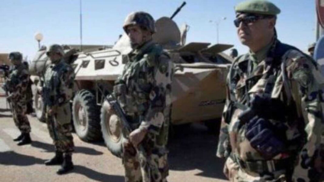 Soldats de l'armée algérienne en patrouille avec véhicule blindé.