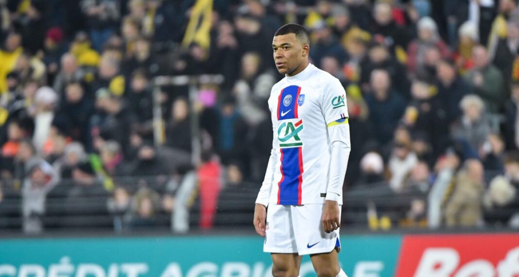 Kylian Mbappé en tenue de football sur le terrain.