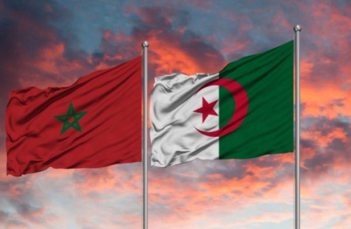 Drapeaux du Maroc et de l'Algérie flottant au coucher du soleil.