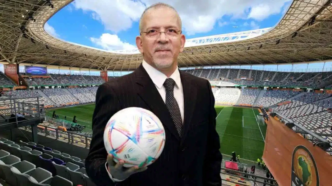Hafid Derradji avec un ballon de football dans un stade vide.
