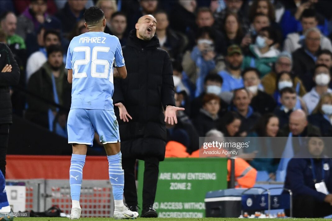 Mahrez et Guardiola en discussion sur le terrain de football.