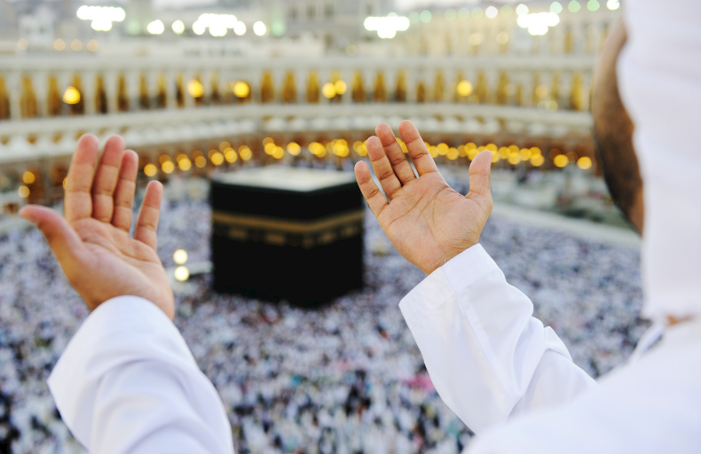 Prieur en prière à La Mecque pendant le Hadj, vue de dos.