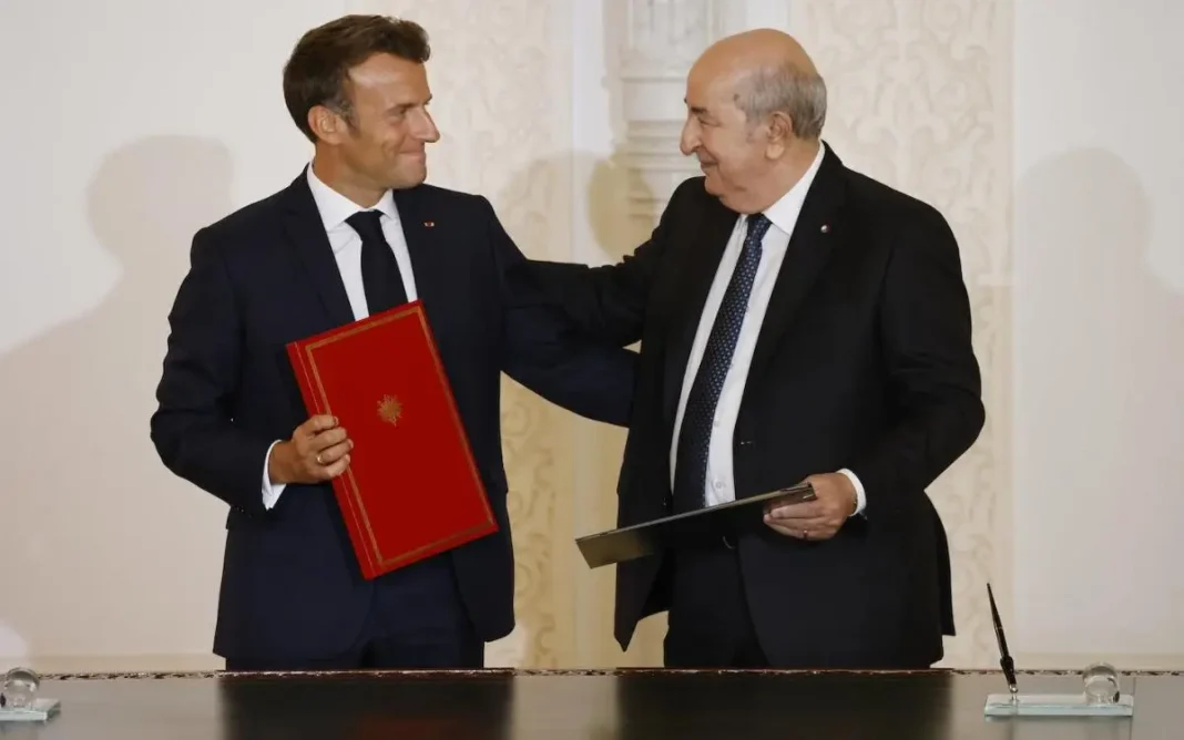Deux hommes en costume signent un accord, échangeant un document officiel.