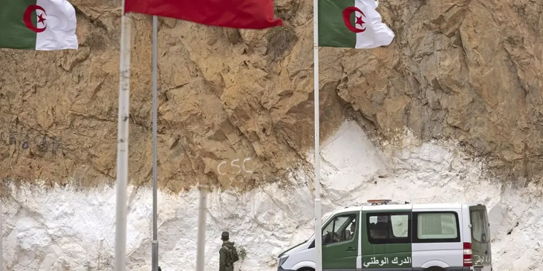Véhicule militaire algérien devant un mur de roches.
