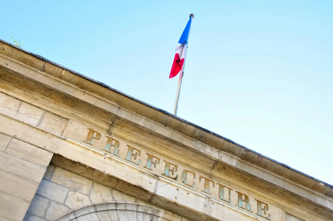 Drapeau français flottant au-dessus d'une préfecture en France.