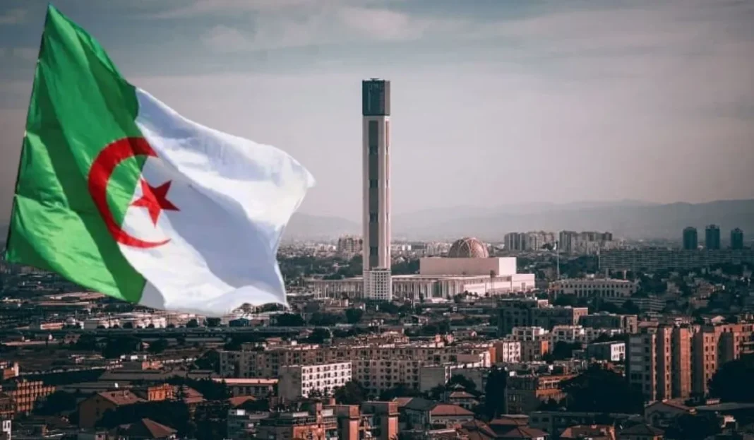 Drapeau algérien flottant avec la ville d'Alger en arrière-plan.