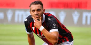Amine Gouiri, joueur de football, en pleine réflexion sur le terrain.