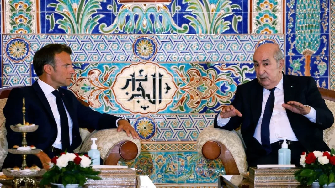 Deux hommes en discussion dans un décor traditionnel algérien.