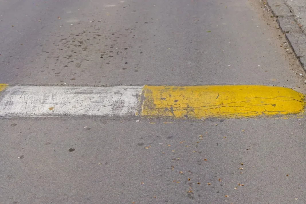 Marquage au sol jaune et blanc usé sur la route en Algérie.