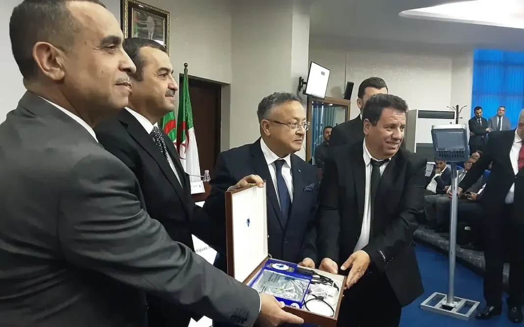 Cinq hommes en costume lors d'une cérémonie de remise de batteries lithium.