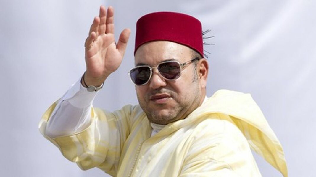 Homme portant fez, lunettes de soleil, saluant avec la main.