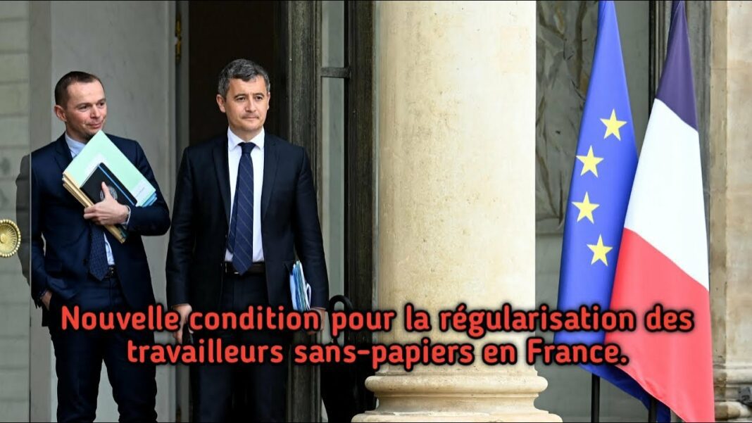 Deux hommes en costume devant un bâtiment avec drapeaux français et européen.