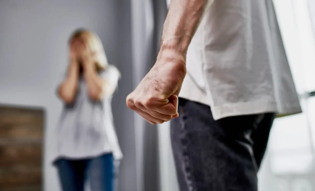 Conflit familial et violence domestique Homme en colère pointant du doigt, femme effrayée en arrière-plan.