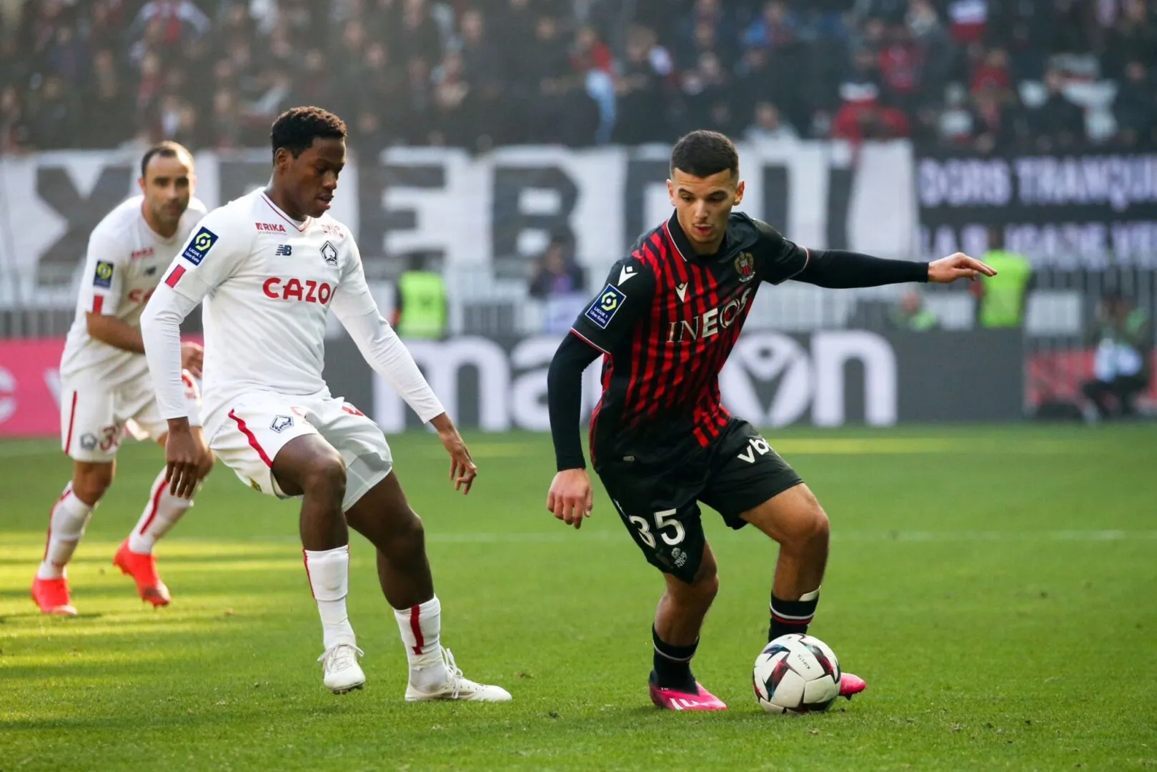 Retour triomphal de Badredine Bouanani à Nice : un nouveau départ pour le talent algérien Joueur en noir contrôlant le ballon face à un adversaire en blanc.
